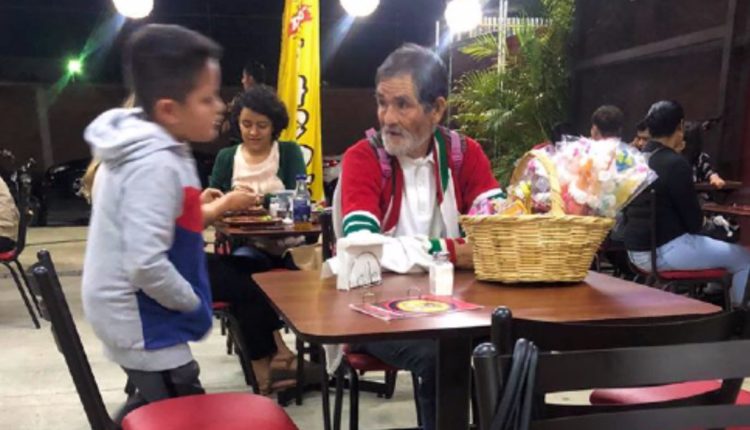 niño compra tacos anciano